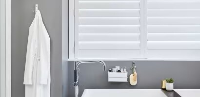 使用無痕&trade; 金屬飾面掛鈎掛起浴袍、置物籃收納物品