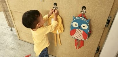 孩子將背包掛上無痕&trade; 金屬掛鈎